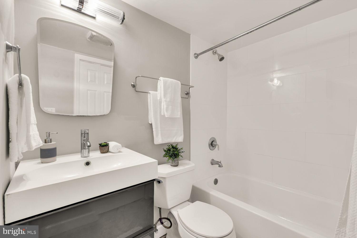 1750 Harvard Street Northwest, Unit 3C Washington, DC 20009 - Photo 18 of 29 a bathroom with a bathtub shower sink vanity mirror and toilet