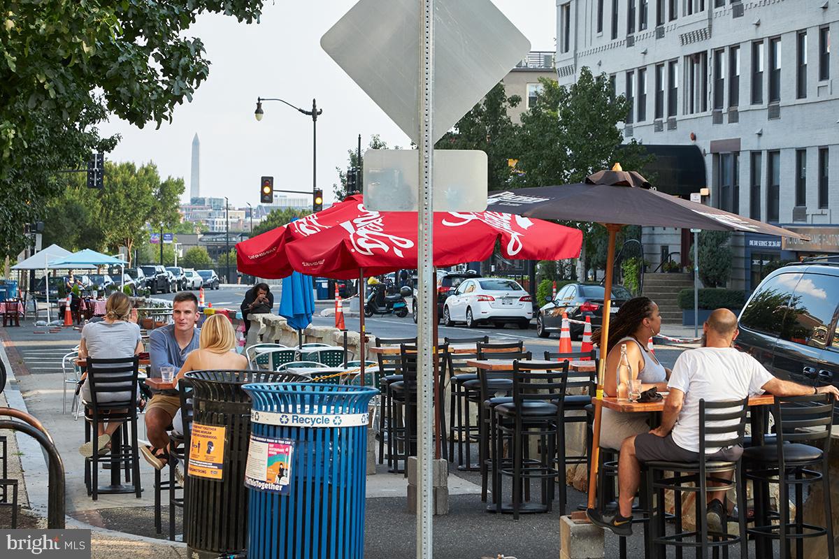 1750 Harvard Street Northwest, Unit 3C Washington, DC 20009 - Photo 28 of 29 a store with outdoor seating area and blue umbrellas