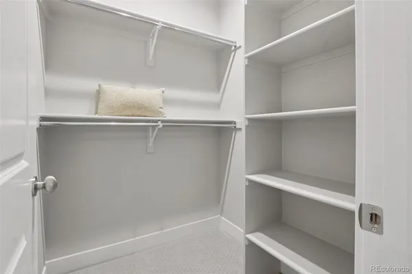 a spacious bedroom with a bed and a painting on the wall