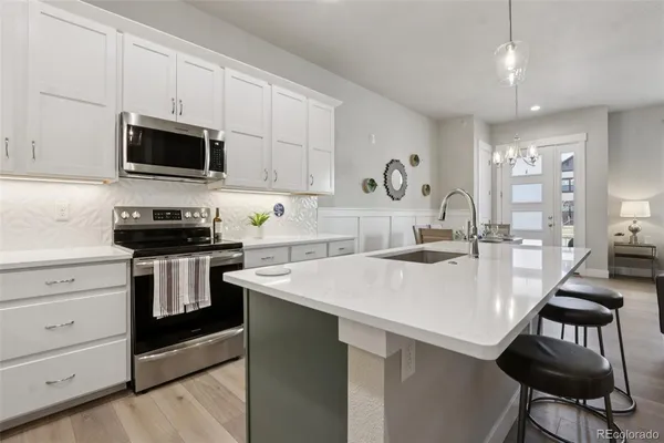 a kitchen with a sink a stove and chairs