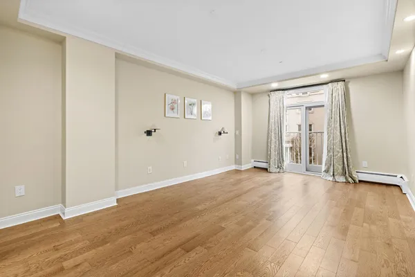 a view of an empty room with wooden floor