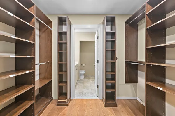 a view of walk in closet with empty racks