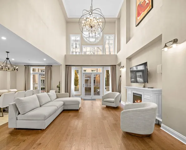 a living room with furniture chandelier and a flat screen tv