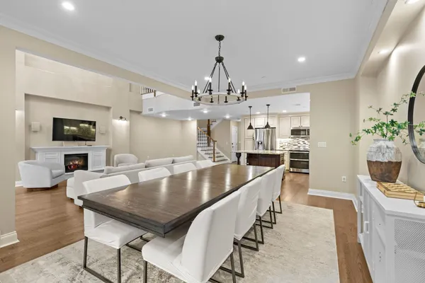 a dining room with furniture a chandelier and wooden floor