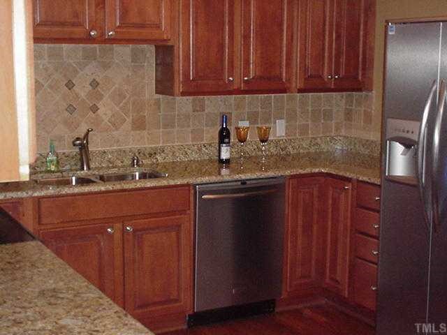 512 Chamberlain Street Raleigh, NC 27607 - Photo 3 of 11 a kitchen with stainless steel appliances granite countertop wooden cabinets a sink and dishwasher