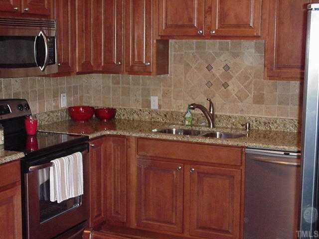 512 Chamberlain Street Raleigh, NC 27607 - Photo 4 of 11 a kitchen with granite countertop a sink dishwasher stove and cabinets with wooden floor