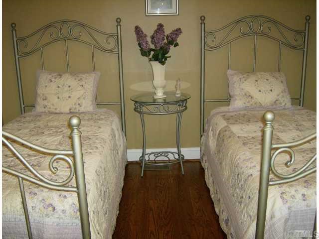 512 Chamberlain Street Raleigh, NC 27607 - Photo 9 of 11 a bedroom with a bed and a chandelier