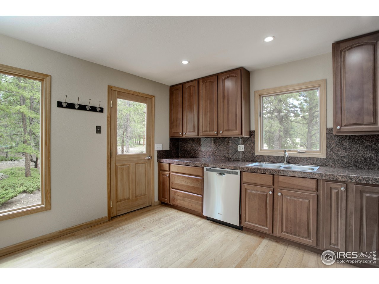 1927 Ridge Road Nederland, CO 80466 - Photo 23 of 38 a kitchen with granite countertop white cabinets a sink a window and stainless steel appliances