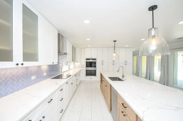 a large white kitchen with a large window