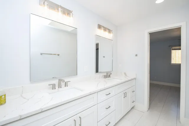 a bathroom with a bathtub and a double vanity sink
