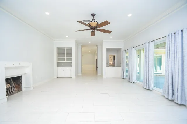 a view of a livingroom with a ceiling fan window and a fireplace