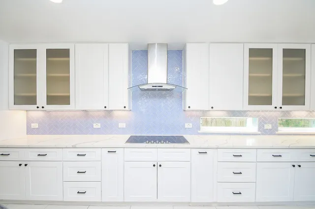 a kitchen with granite countertop white cabinets and a window