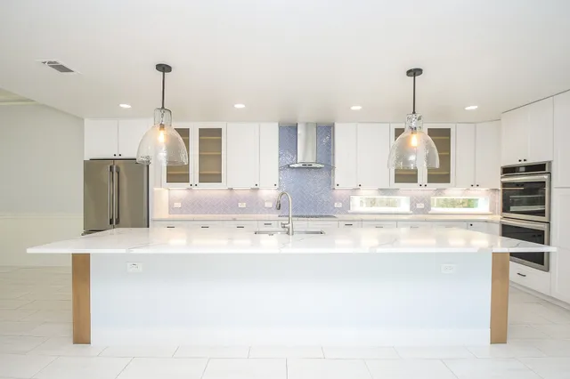 a kitchen with kitchen island a counter top space appliances and cabinets