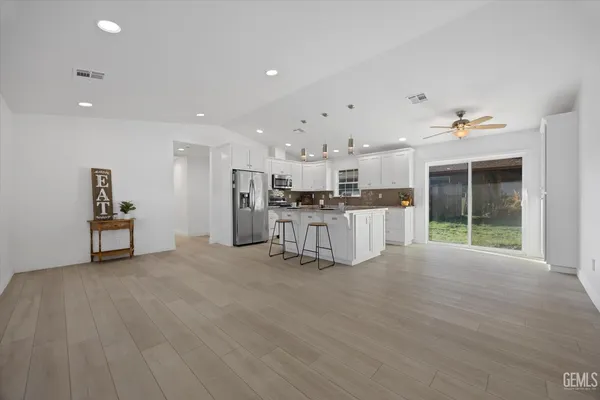 a view of an empty room with window and refrigerator