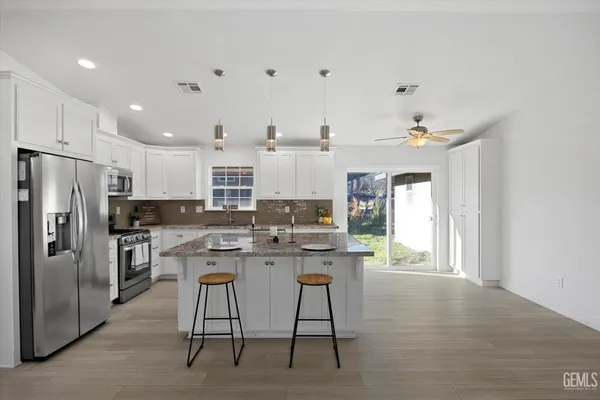 a kitchen with stainless steel appliances kitchen island granite countertop a stove and a sink