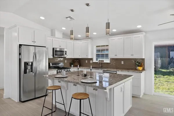 a kitchen with granite countertop a stove sink and cabinets