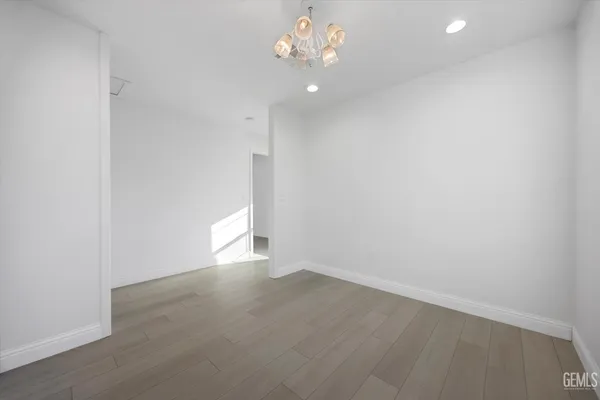 an empty room with ceiling fan and wooden floor