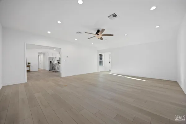 an empty room with windows and fan