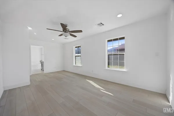 an empty room with a ceiling fan and window
