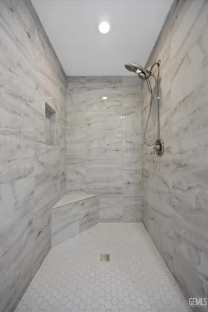 a view of an empty room with wooden floor and a ceiling fan