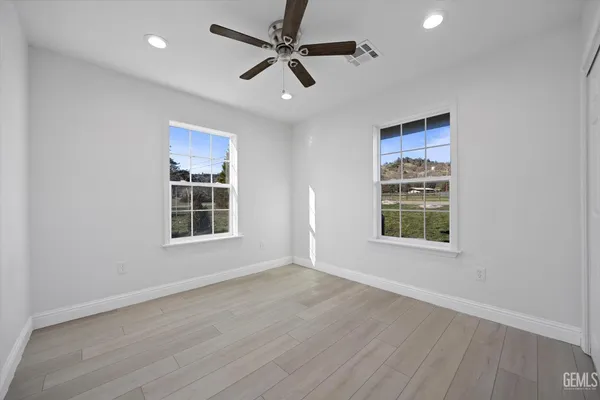 a bathroom with a sink a toilet a mirror a vanity and shower