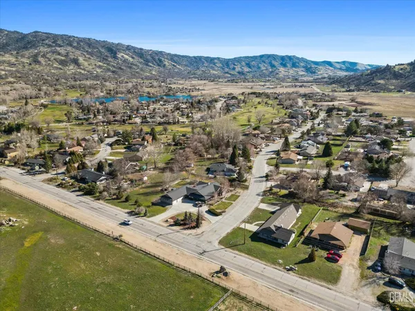 a view of a house next to a yard with large trees