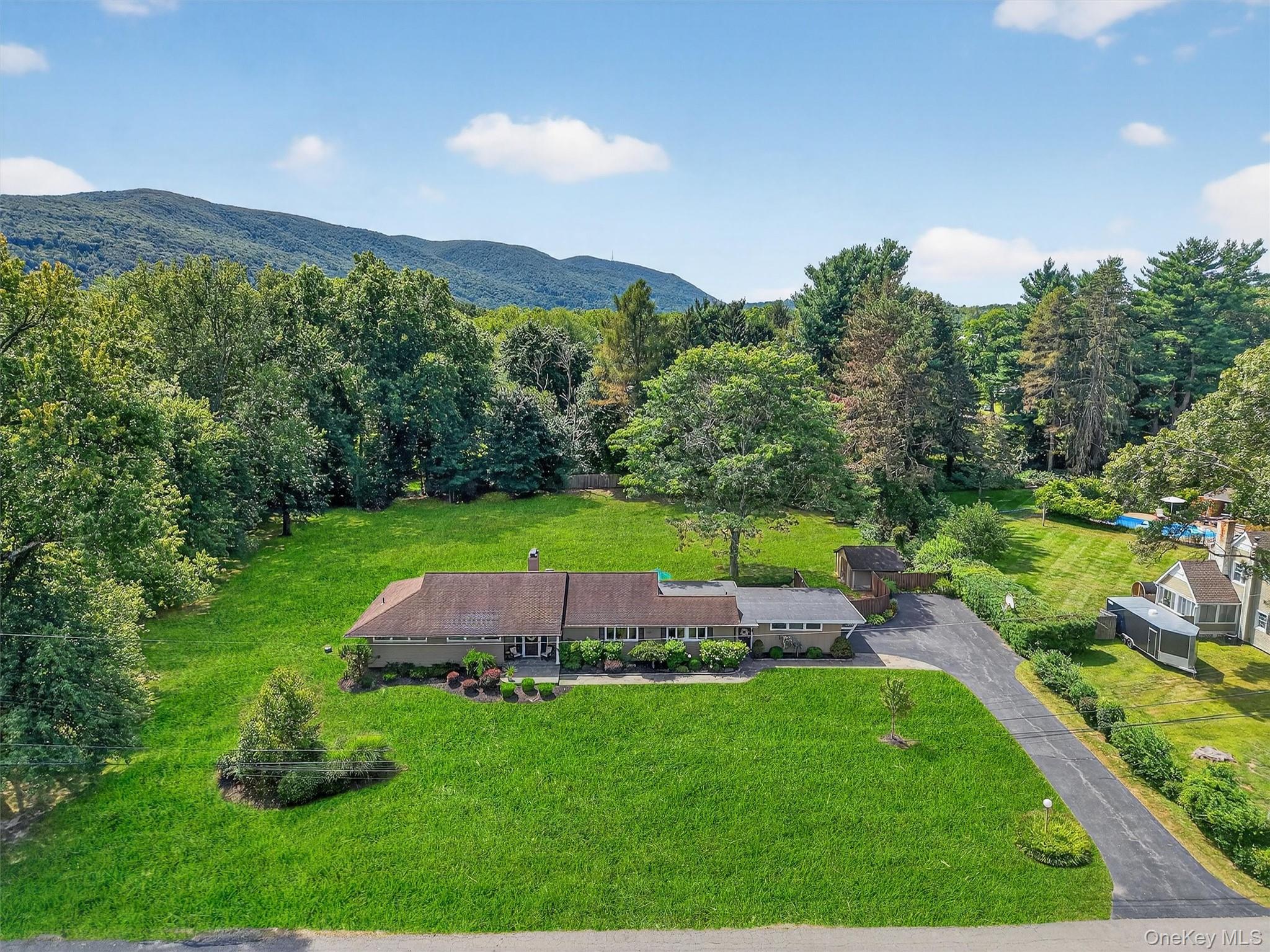 View from above of property with a heavily wooded area and mountains