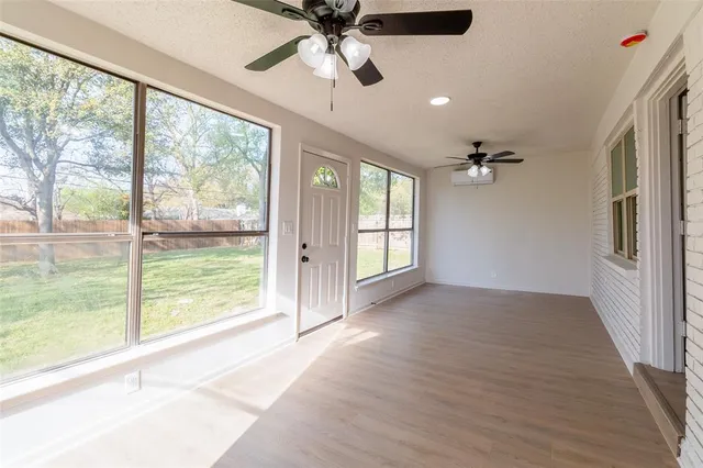 a view of an empty room with a window and a ceiling fan