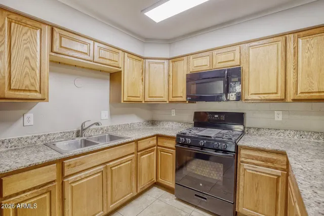 a kitchen with granite countertop a sink stainless steel appliances and cabinets