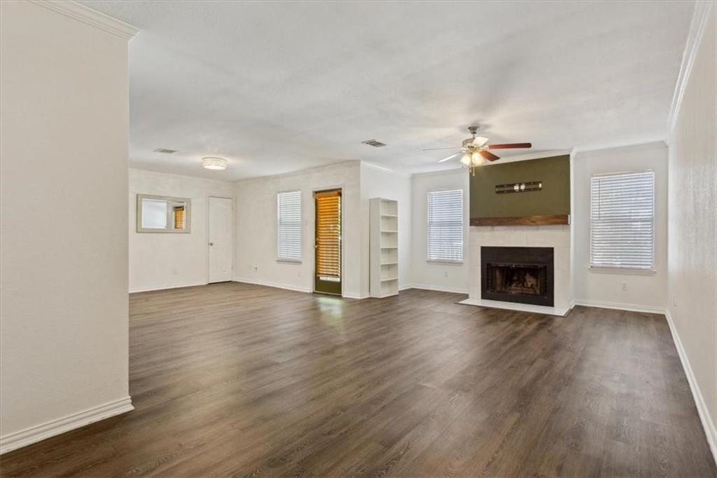 2306 Melissa Drive Waco, TX 76708 - Photo 5 of 22 an empty room with wooden floor fireplace and windows