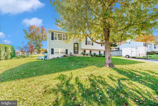 a view of a house with a big yard and large trees