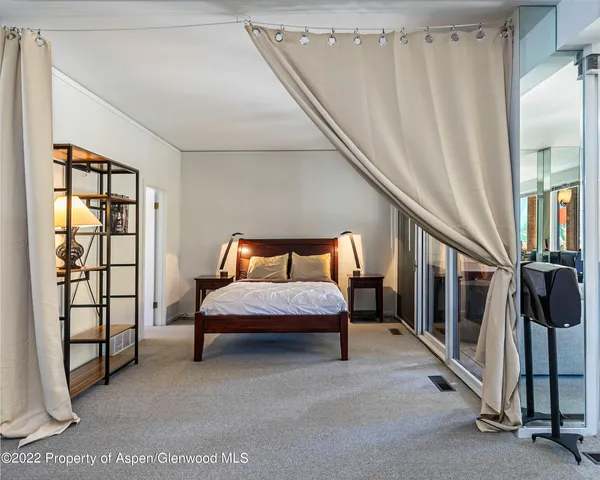 a spacious bedroom with a bed and a window