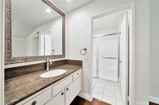 a bathroom with a granite countertop sink and a mirror