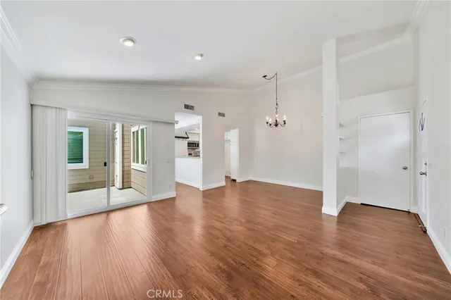 a view of a big room with wooden floor and windows