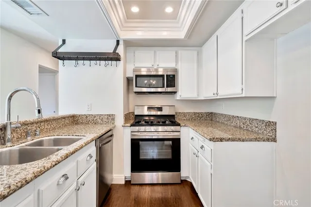 a kitchen with granite countertop a stove sink and cabinets