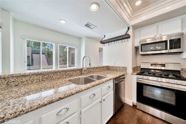 a kitchen with stainless steel appliances granite countertop a sink and a stove