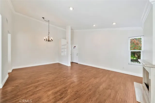 a view of empty room with wooden floor and window