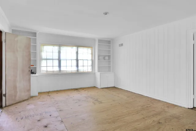 an empty room with a empty space and windows