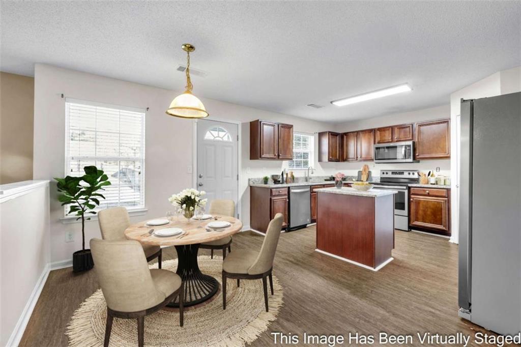6724 Overlook Ridge College Park, GA 30349 - Photo 11 of 34 a kitchen room with stainless steel appliances granite countertop a stove a refrigerator a kitchen island a dining table and chairs