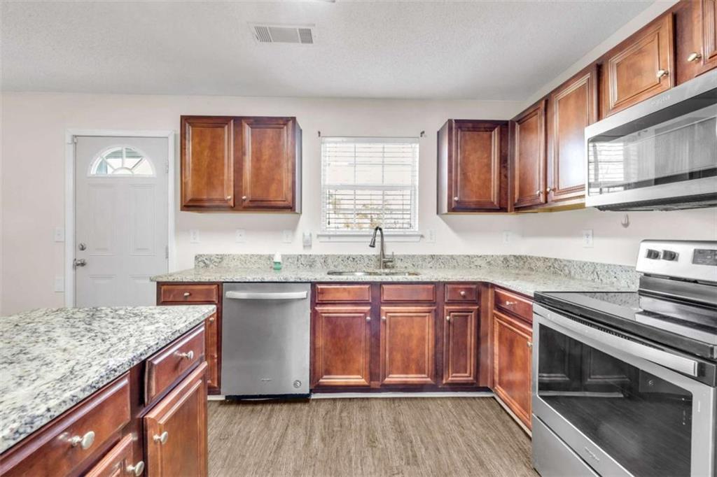 6724 Overlook Ridge College Park, GA 30349 - Photo 14 of 34 a kitchen with stainless steel appliances granite countertop a sink stove and cabinets