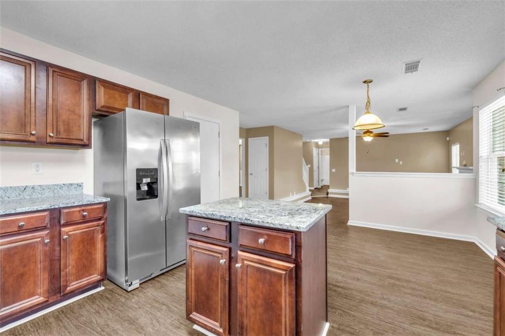 6724 Overlook Ridge College Park, GA 30349 - Photo 15 of 34 a kitchen with stainless steel appliances granite countertop a refrigerator a sink dishwasher and wooden cabinets with wooden floor