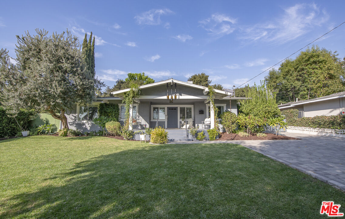 a front view of a house with a garden and sitting area