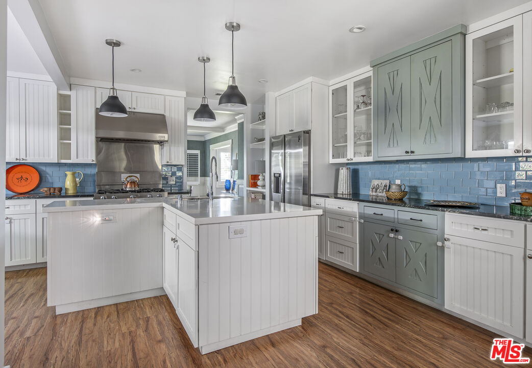 55 West Altadena Drive Altadena, CA 91001 - Photo 16 of 42 a kitchen with stainless steel appliances granite countertop a sink a stove a refrigerator and cabinets with wooden floor