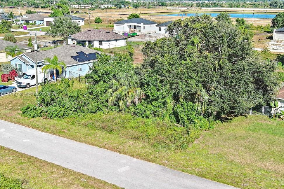 341 Ranchito Avenue Lehigh Acres, FL 33974 - Photo 5 of 22 an aerial view of residential houses with outdoor space and trees