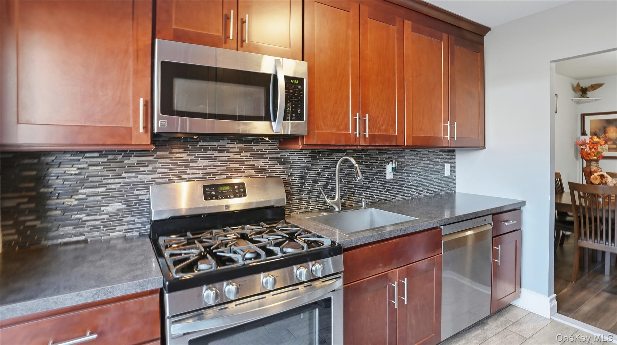 460 Old Town Road, Unit 28A East Setauket, NY 11766 - Photo 5 of 28 a kitchen with granite countertop a stove sink and microwave