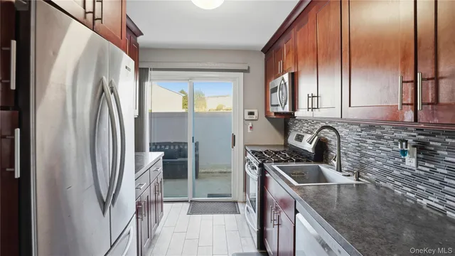 a kitchen with stainless steel appliances granite countertop a refrigerator a sink and a stove
