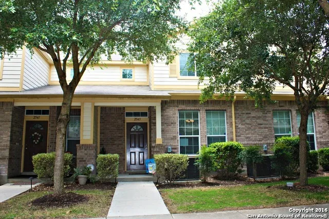 a front view of a house with garden and trees
