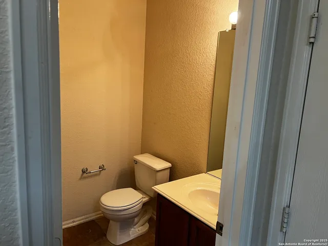 a bathroom with a granite countertop toilet and a sink