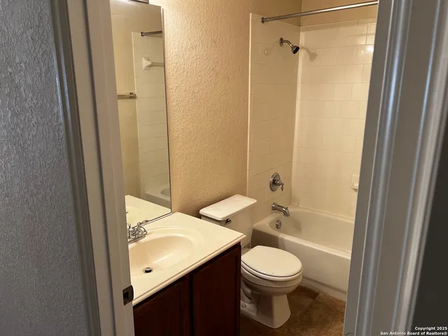 a bathroom with a granite countertop toilet sink and shower