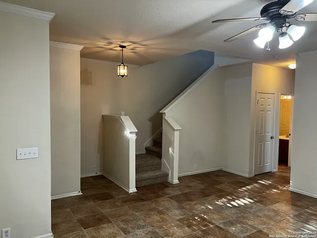 a view of a livingroom with a ceiling fan and entryway